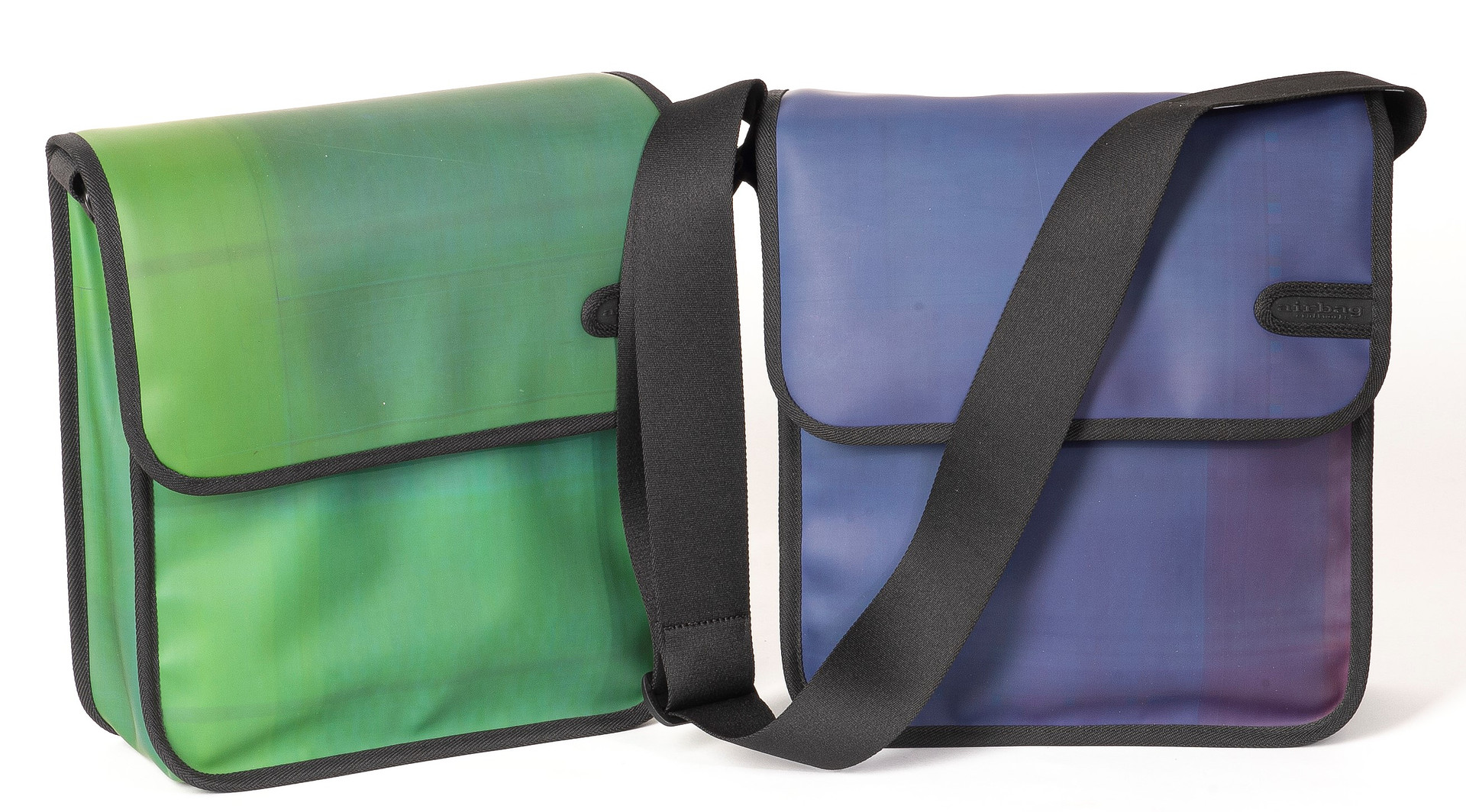 Zwei Taschen: links in hellgrün, rechts in violett-dunkelblau, mit schwarzem Schultergurt 