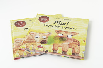 Zwei Kinderbücher mit dem Titel „Phu! Pupsi hat gepupst!“ Auf dem Cover sind zwei Wildschweine gezeichnet. Eine grüne Wolke schwebt vor den Wildschweinen und das eine verdreht die Augen. 
