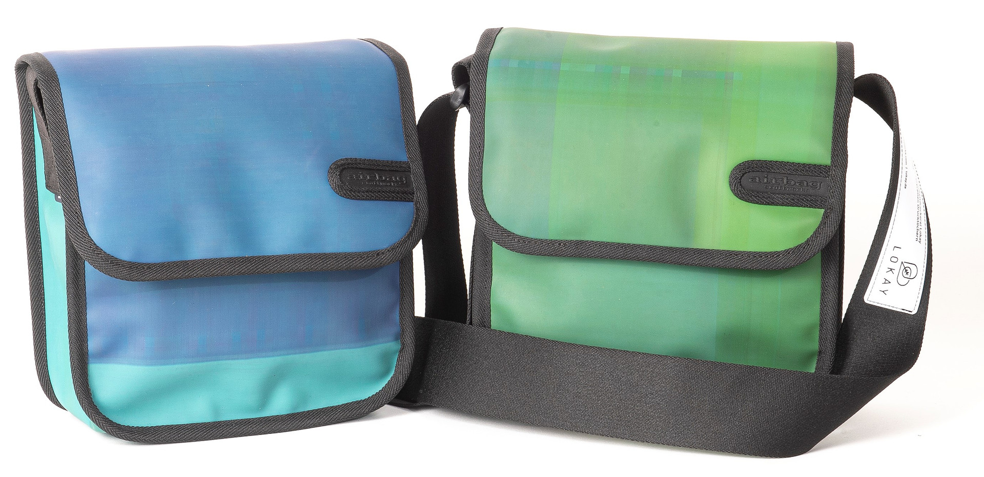 Zwei Taschen: links in hellblau, rechts in hellgrün mit einem schwarzen Schultergurt