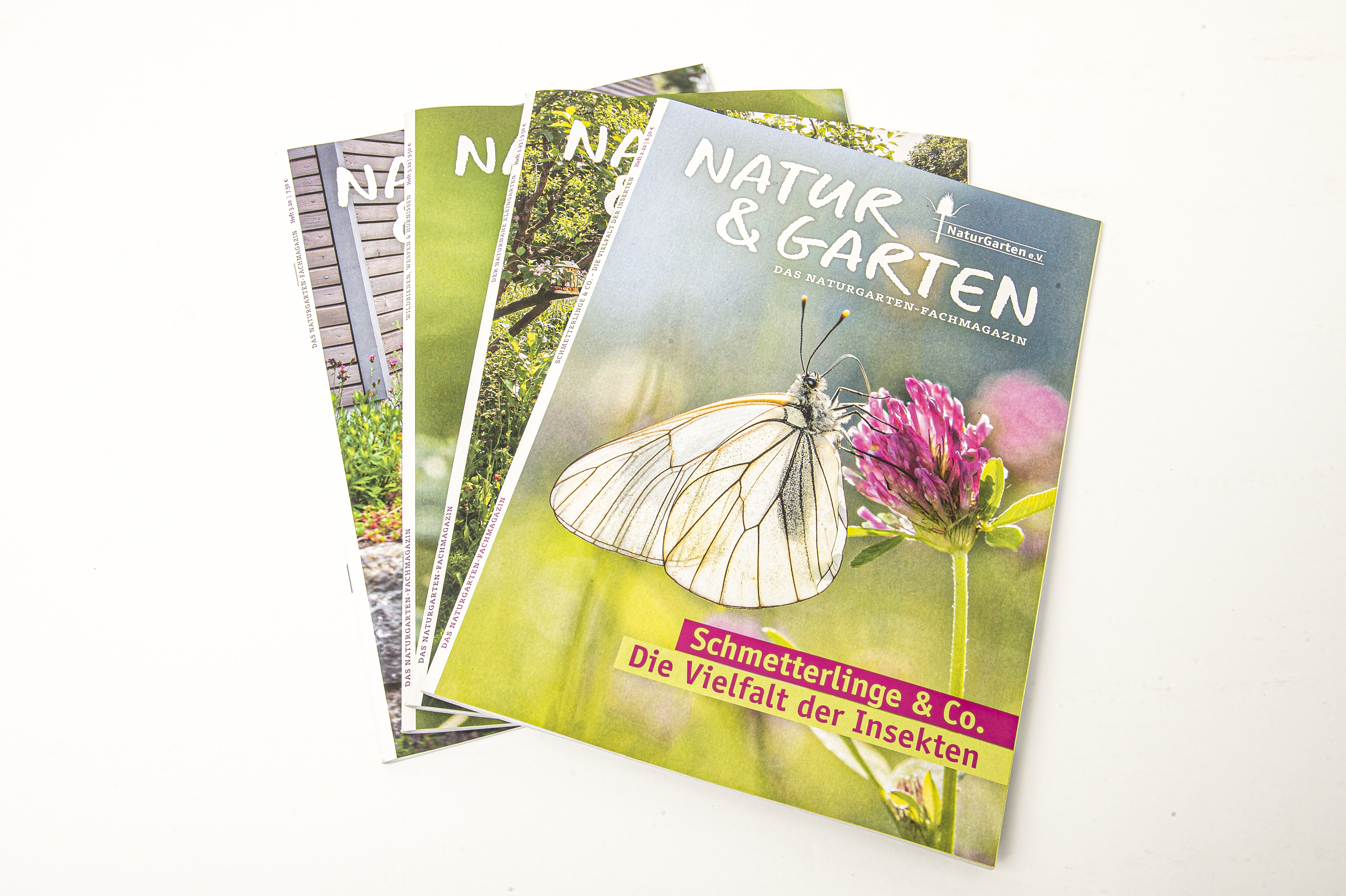 einige Hefte "Natur & Garten" liegen übereinander. Auf dem Cover des oberen Magazins ist ein Foto von einem Schmetterling, der auf einer Blüte sitzt. Darunter steht das Titelthema: "Schmetterlinge & Co. Die Vielfalt der Insekten"