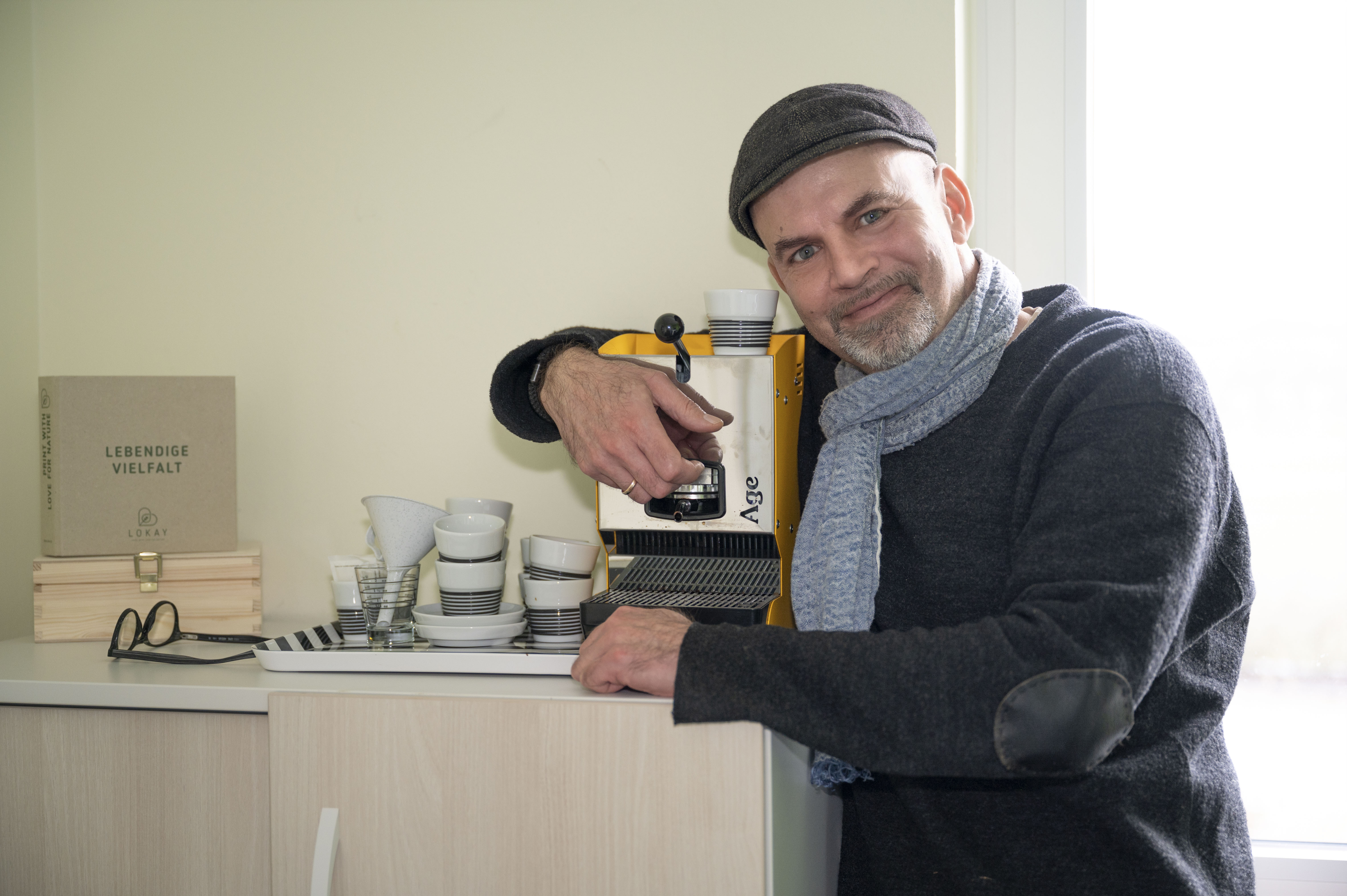 Ein Mann umarmt eine kleine Espressomaschine