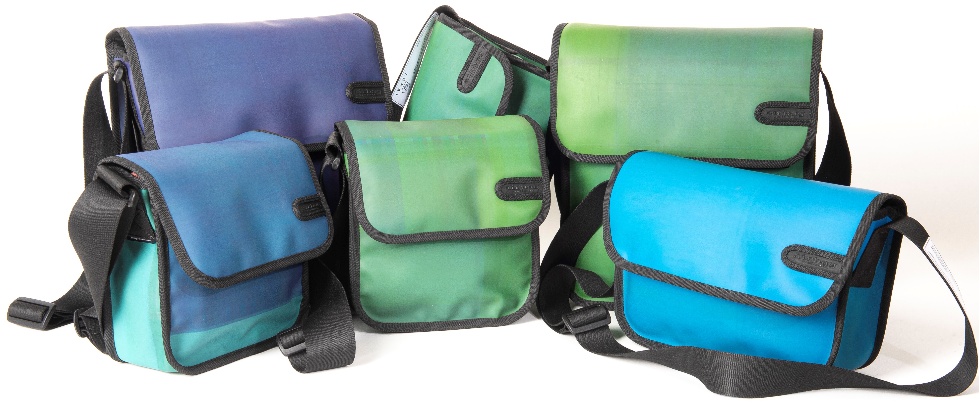 Messenger-Bags in verschiedenen Grün und Blau-Tönen mit schwarzen Schultergurten 