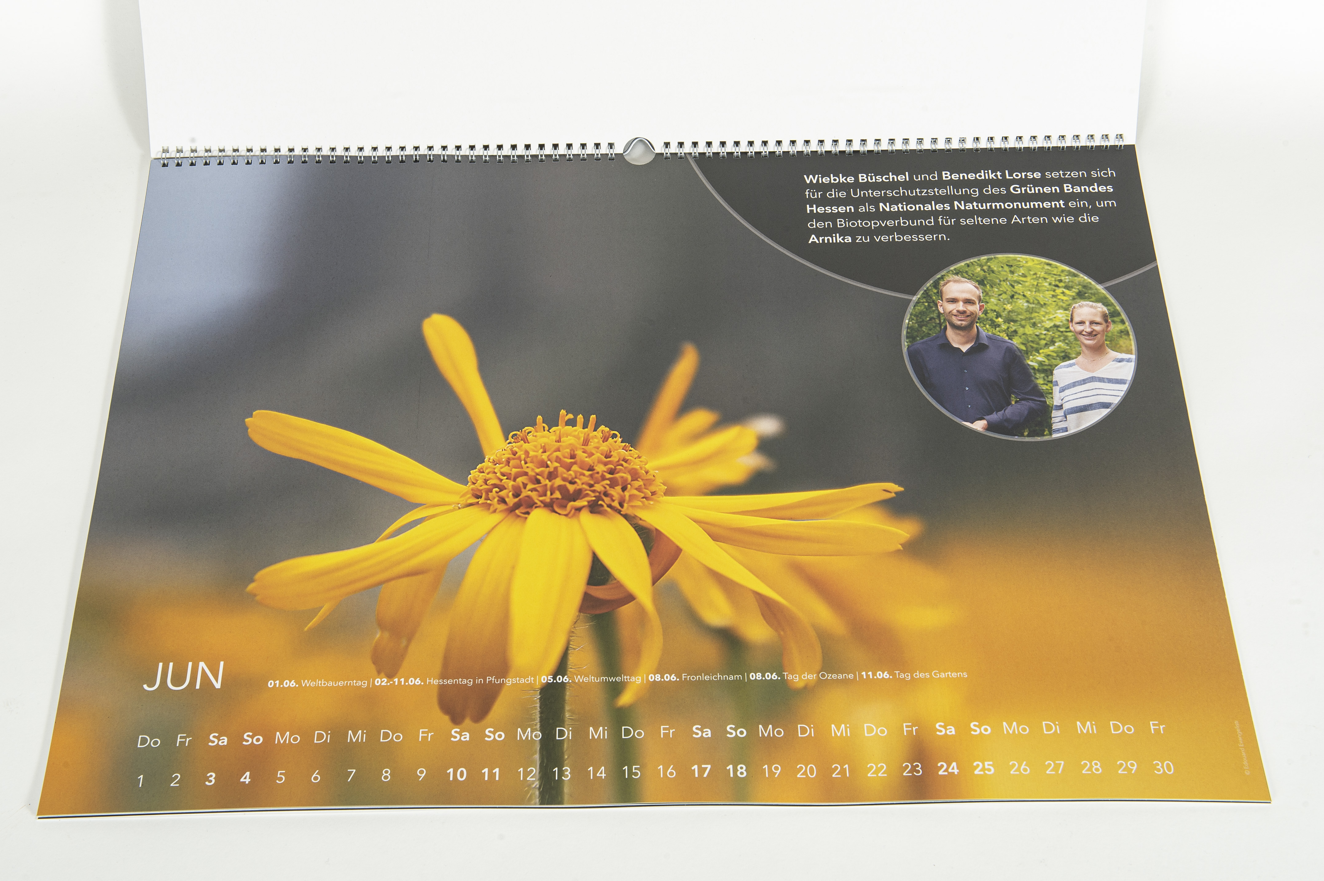 ein aufgeschlagenes Kalenderblatt: Das Foto zeigt eine orangefarbene Blume in Nahaufnahme. 